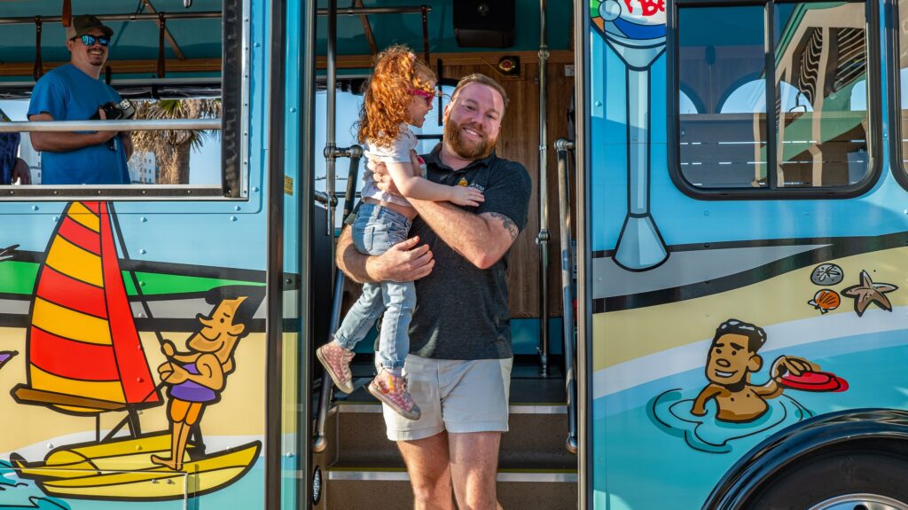 Man and daughter disembarking Pensacola Beach Island Trolley