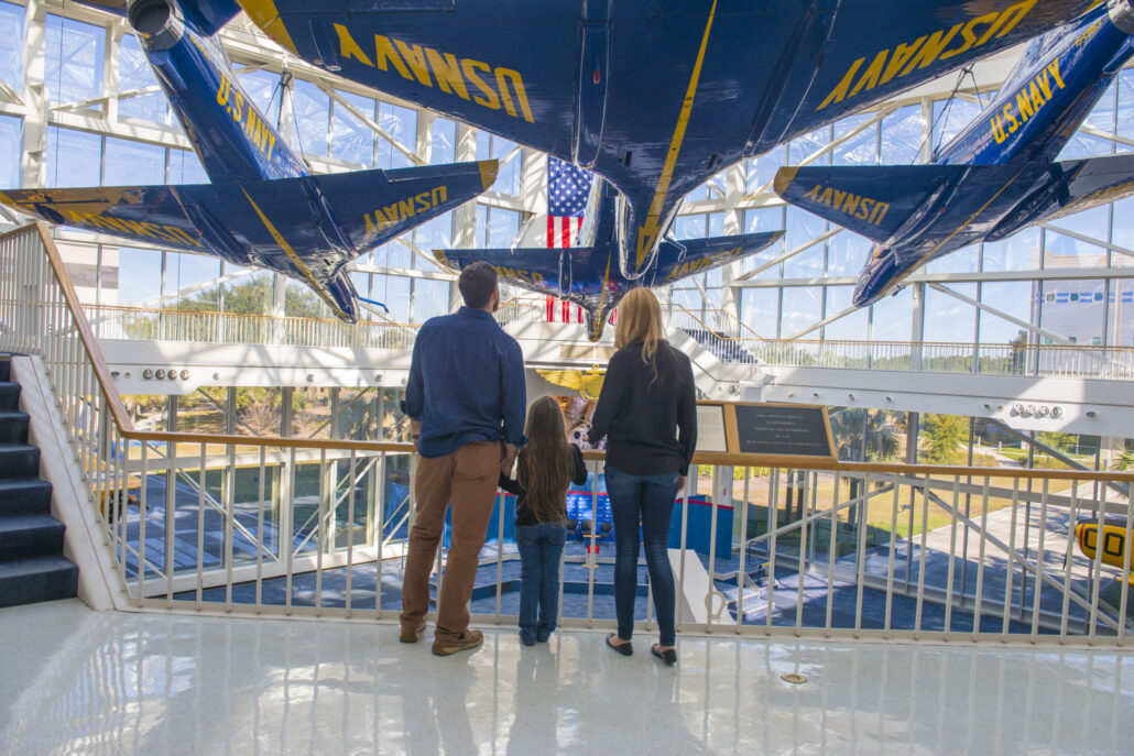 A family standing in the National Naval Aviation Museum Atrium looking at the plannes