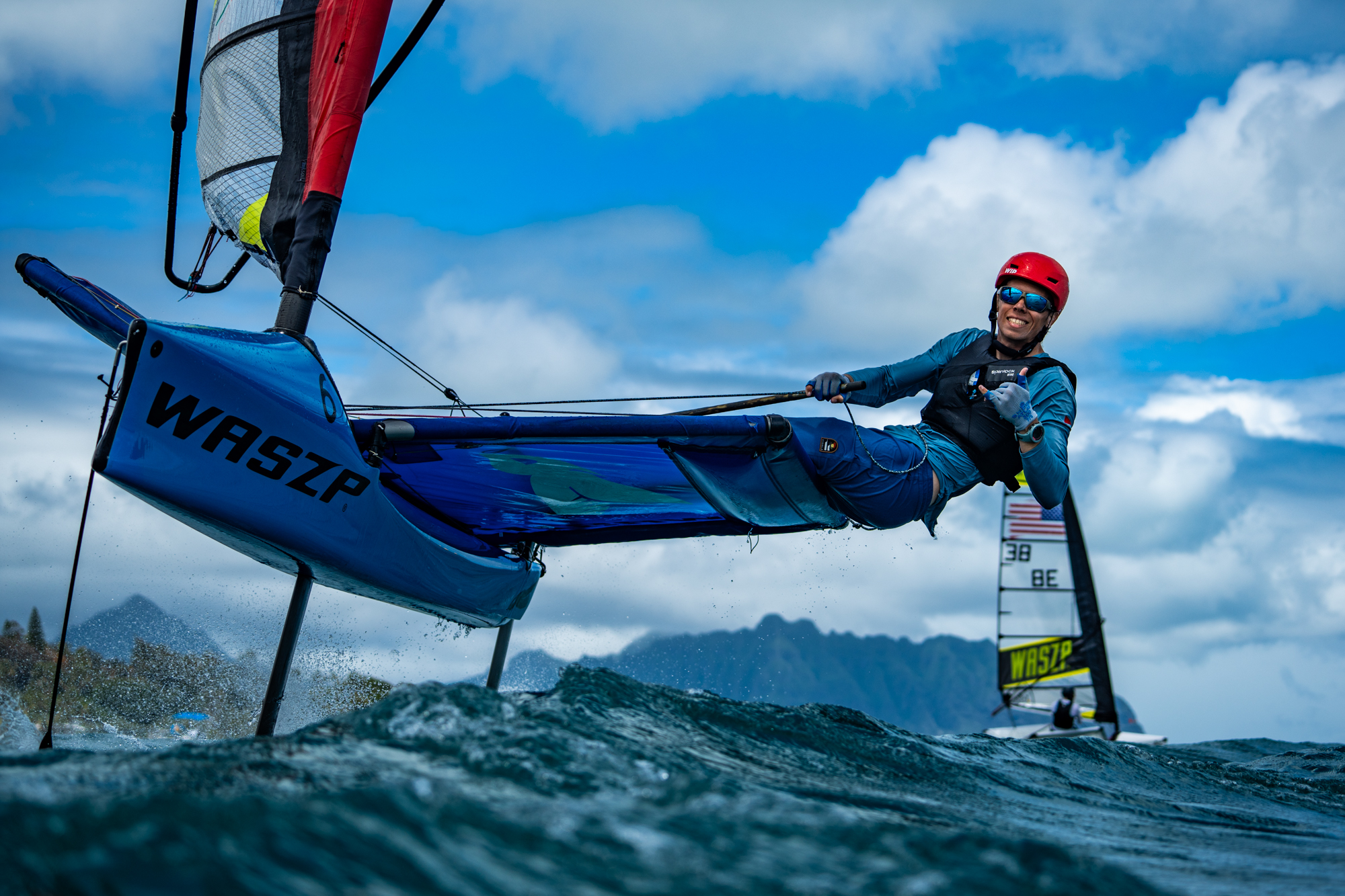 Man on WASZP boat looking at camera and making a hang loose sign with his hand
